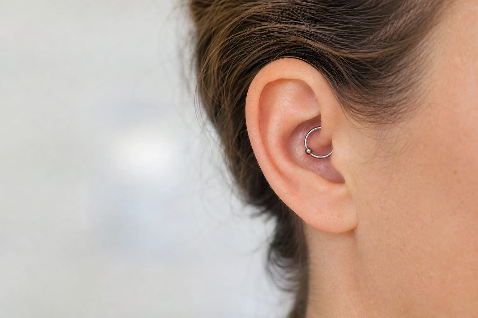 Nærbillede af et øre med en daith piercing i den indre bruskkant